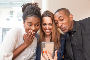 three people looking at mobile phone
